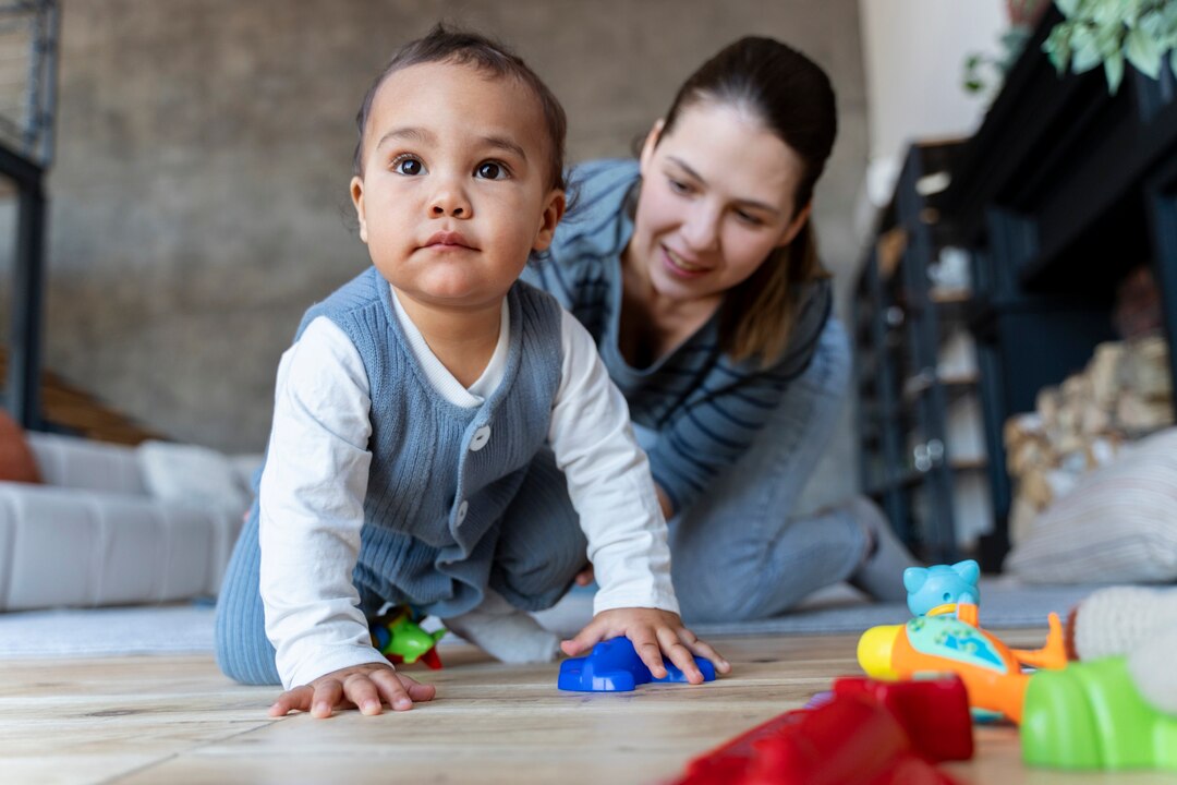 adorable baby crawling floor being helped by his mother 23 2149355583